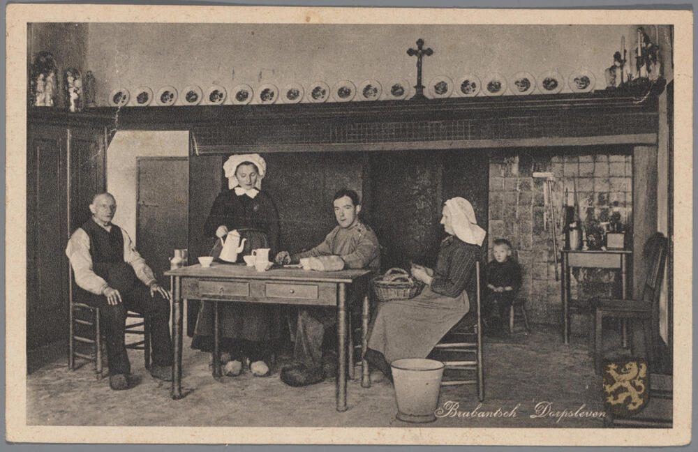 Mannen en vrouwen in Noord-Brabantse streekdracht aan de koffietafel.