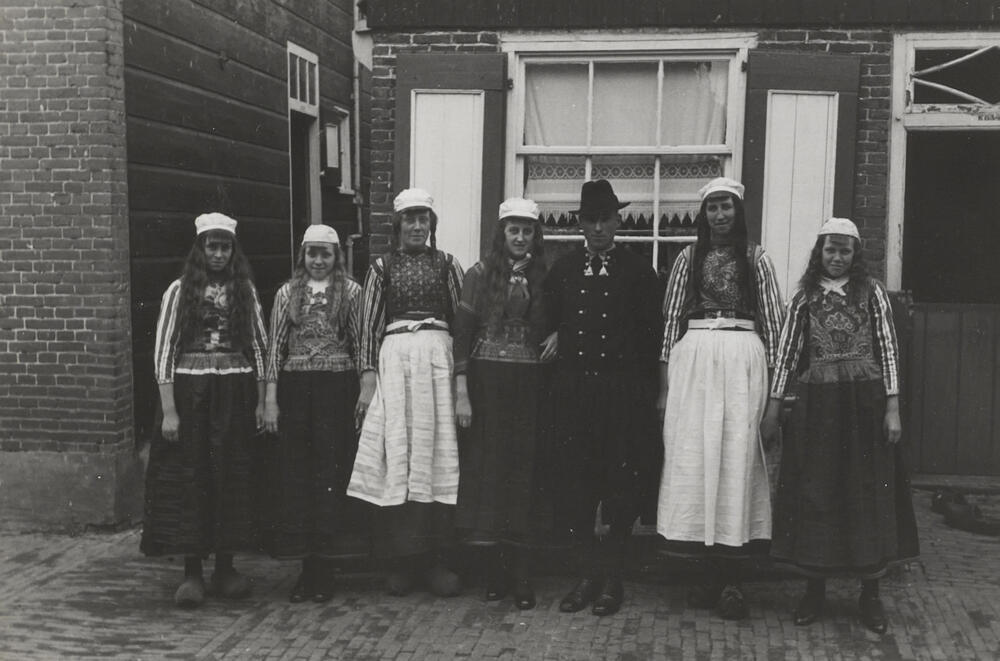 Bruidspaar in ondertrouwpak met bruiloftsgasten, Marken, 1943