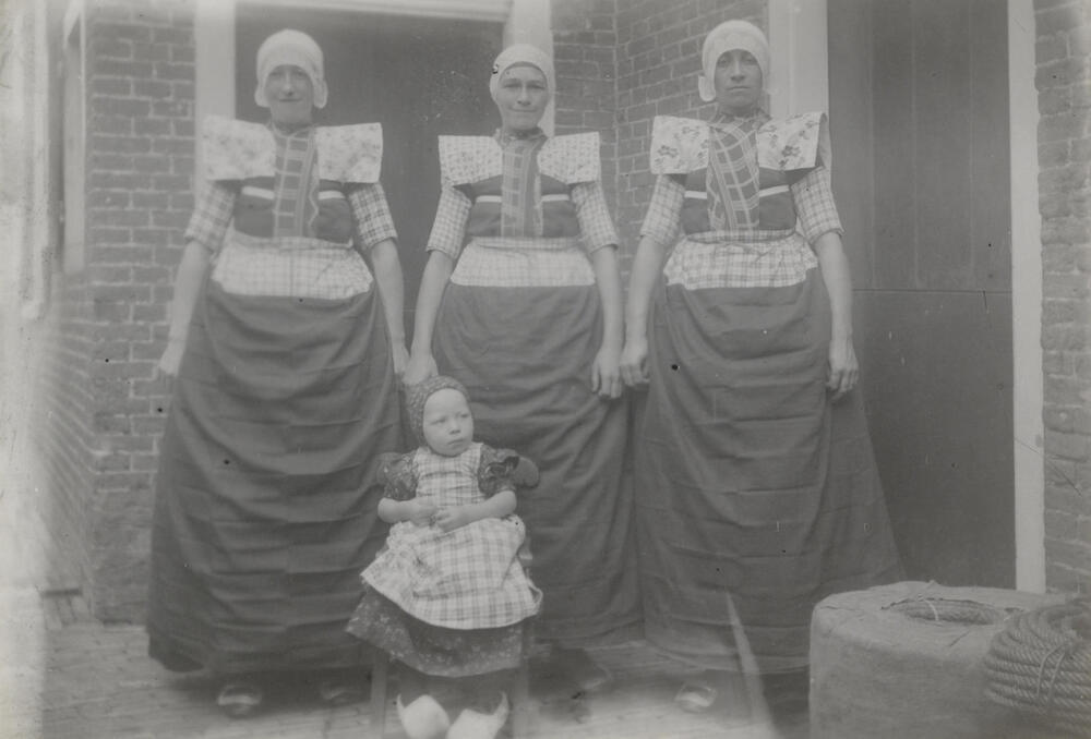 Vrouwen en kind in zondagse dracht van Bunschoten-Spakenburg, circa 1915