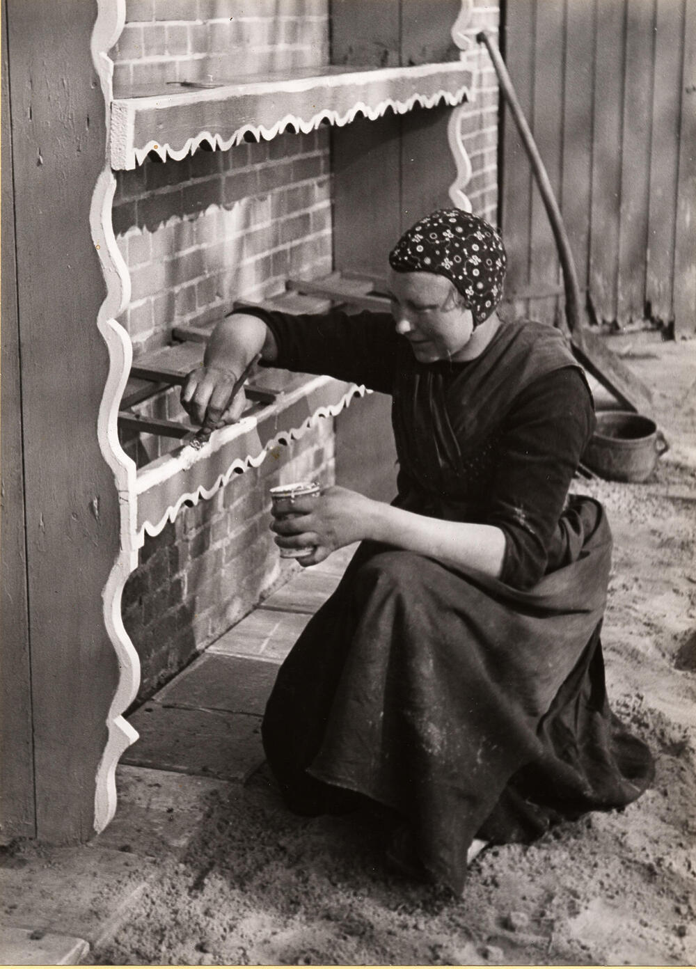 Jantje Hofstede-Slager schildert haar melkbussenrek, Staphorst, 1944