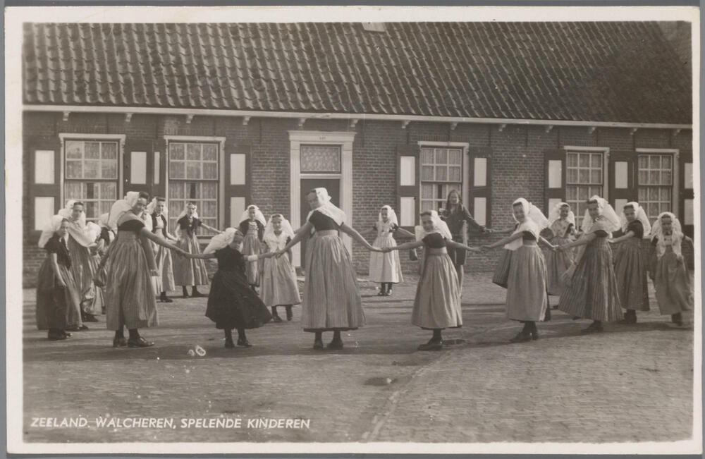 Groep meisjes in Walcherse dracht, spelende een kringspel