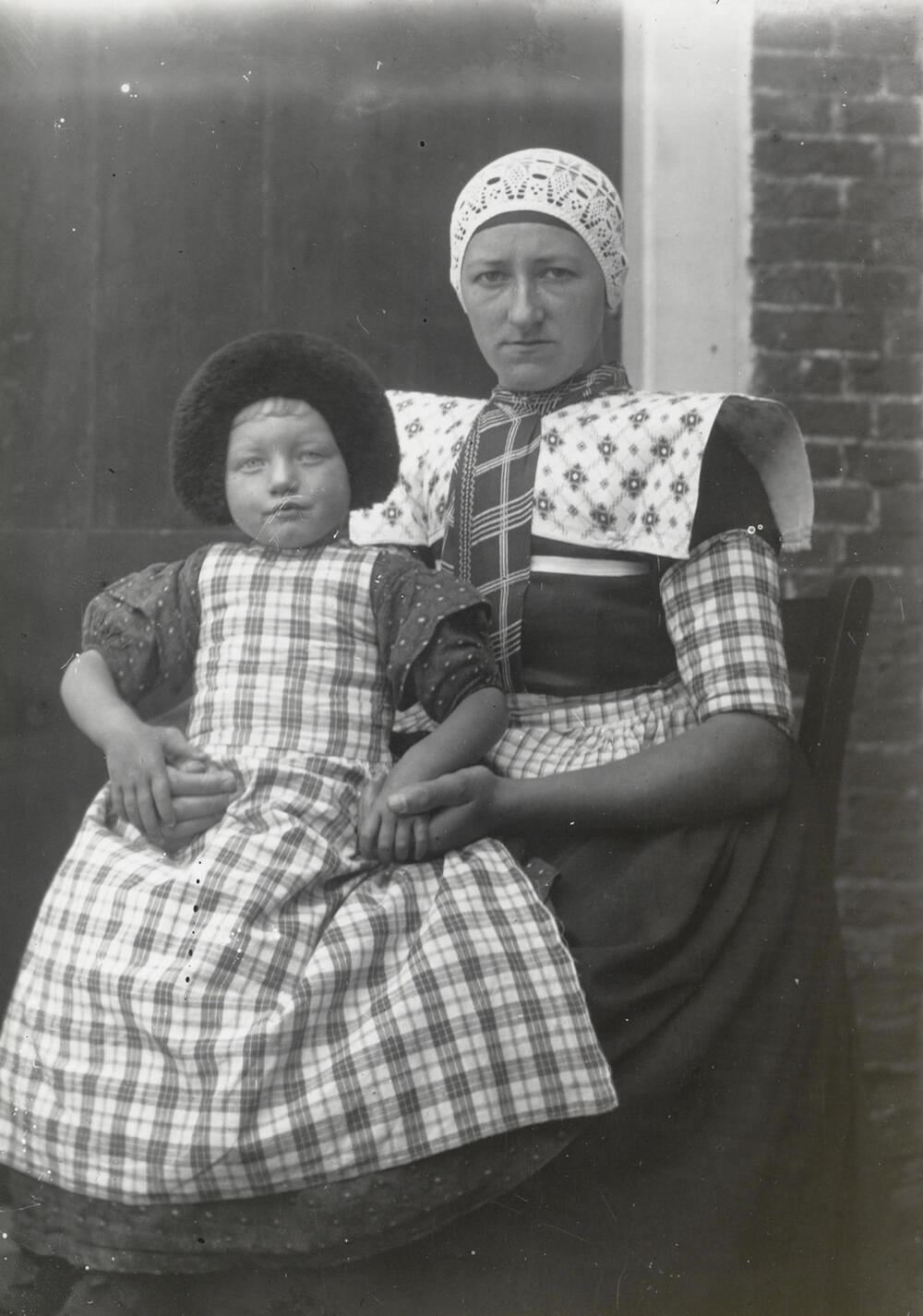 Vrouw en meisje in opknapdracht, Bunschoten-Spakenburg, circa 1915