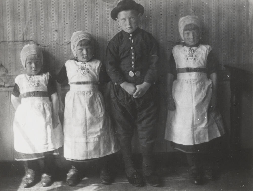Drie meisjes en een jongen in Urker dracht, circa 1916