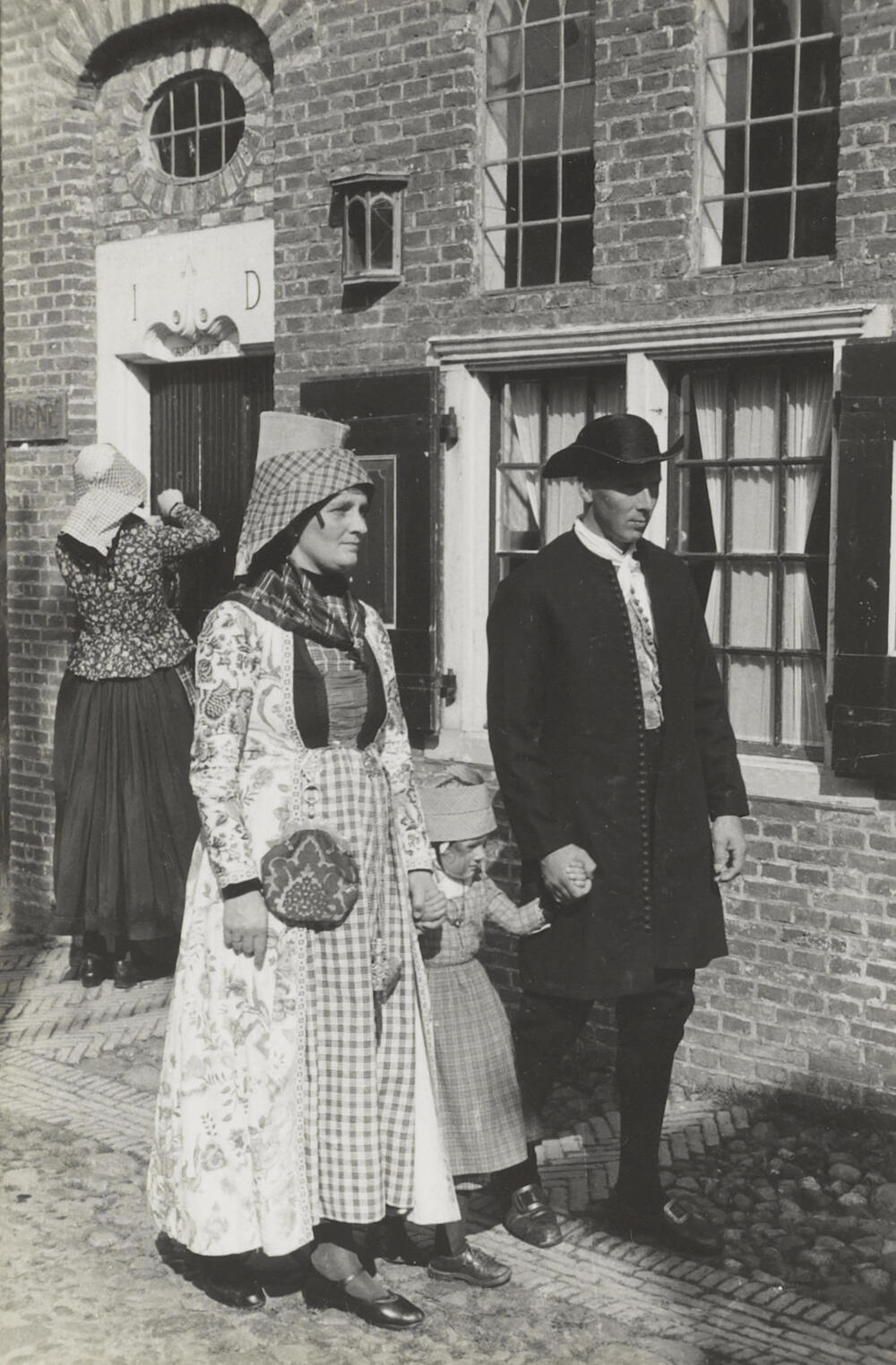 Meisjes, vrouw en man, verkleed in Hindelooper dracht, 1944