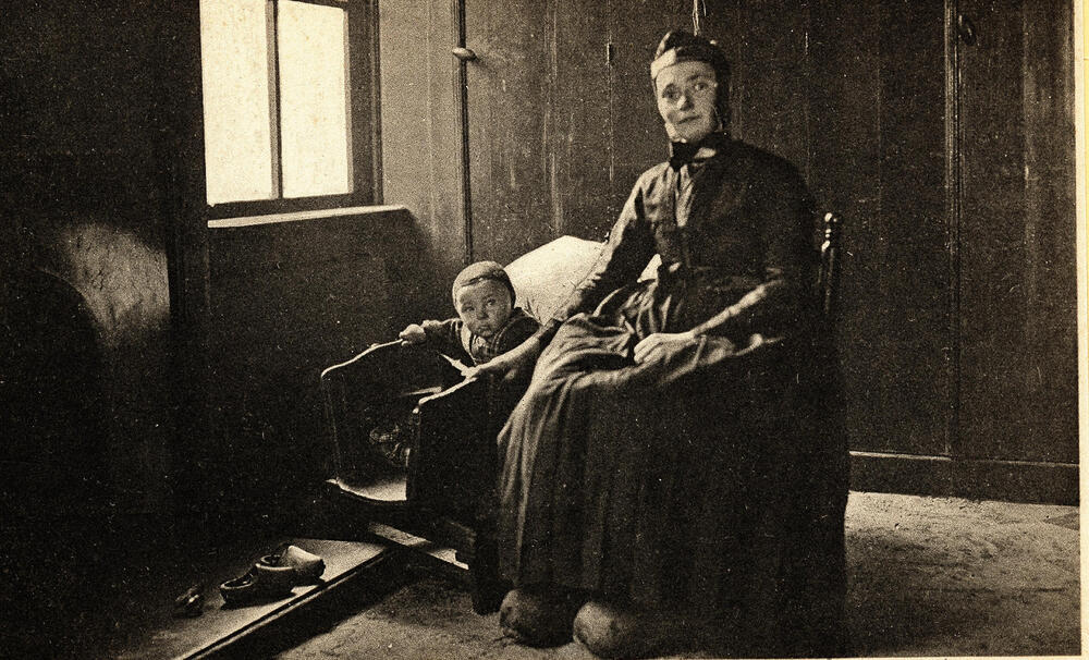 Vrouw en kind bij wieg, Staphorst, 1890–1940