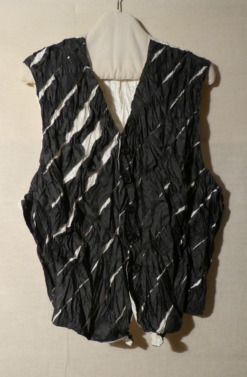 Vest (man) van wit polyester met zwarte diagonalen, duurzaam geplisseerd