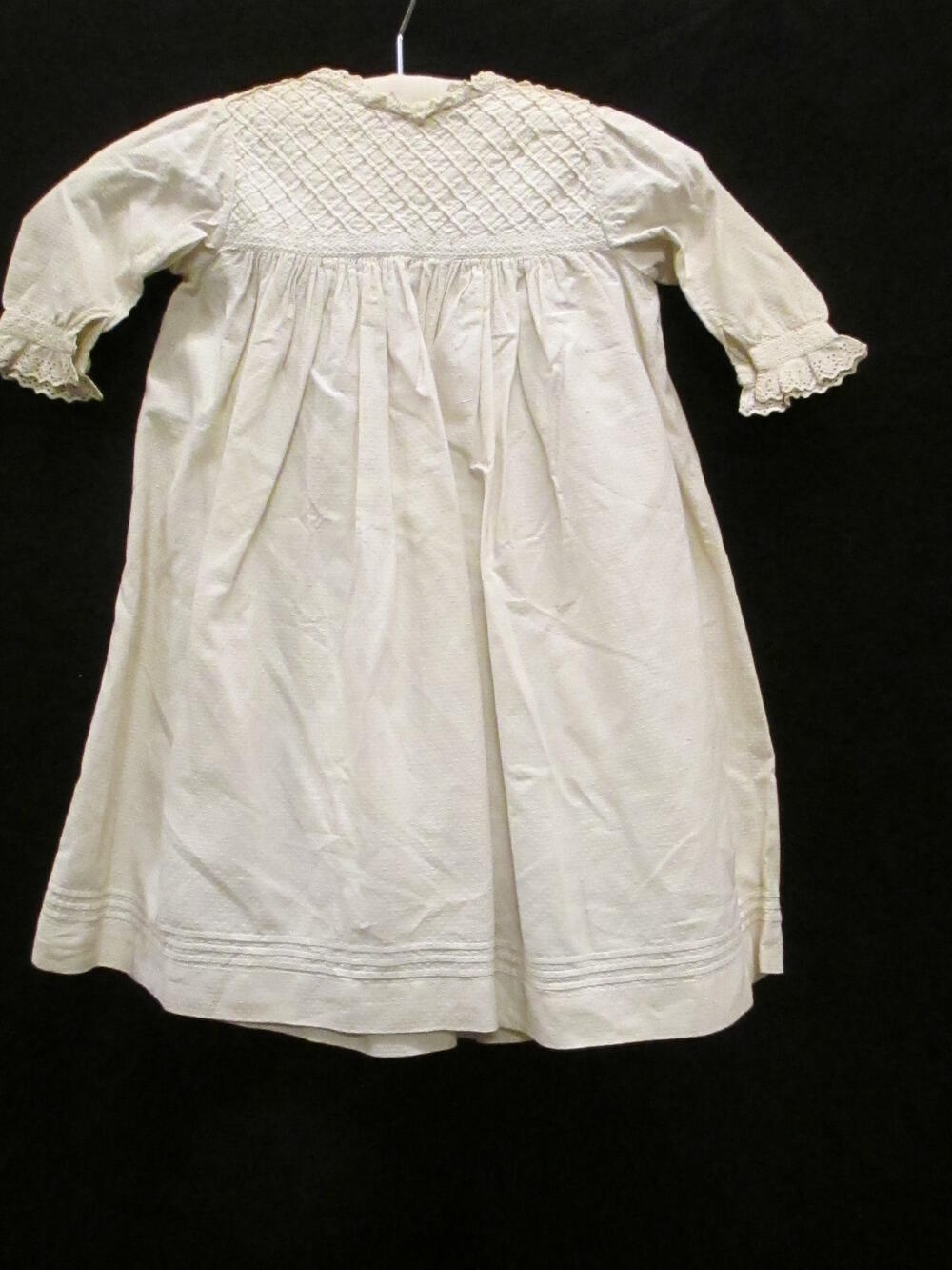 Jurk (kind) van katoen / Schort (kind) van wit katoenen piqué, afgezet met broderie