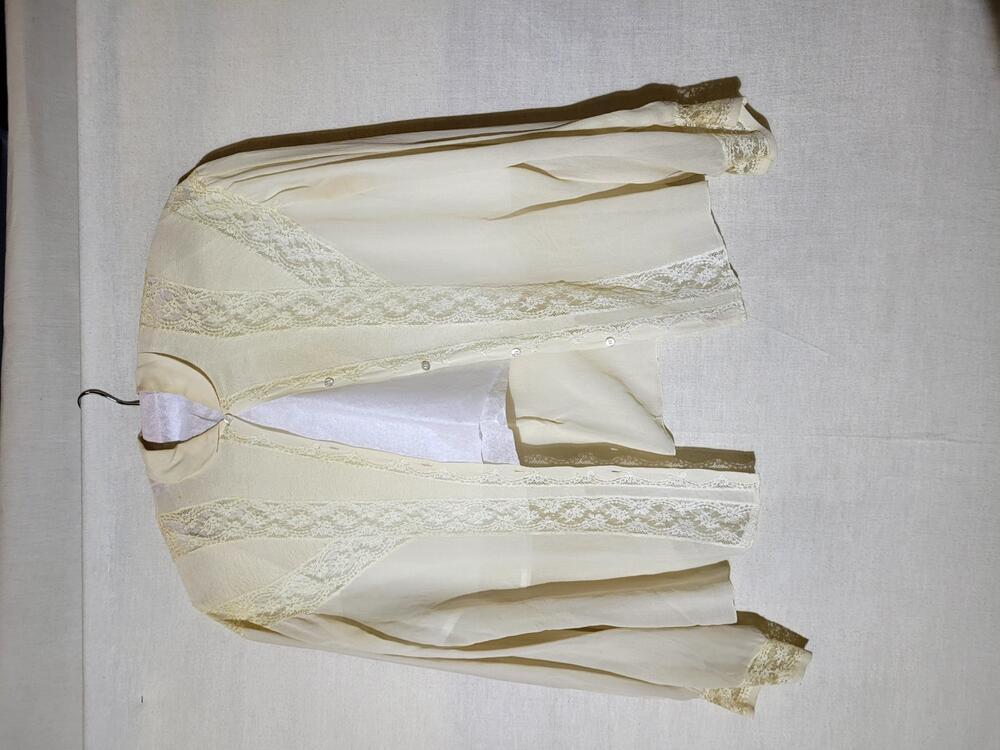 Blouse van crèmekleurige crêpezijde met incrustaties van machinaal kant en decoraties van…