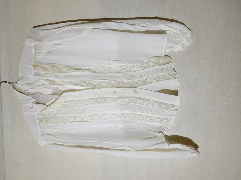 Blouse van witte kunstzijde met entredeux van machinaal kant, sluiting middels transparante…