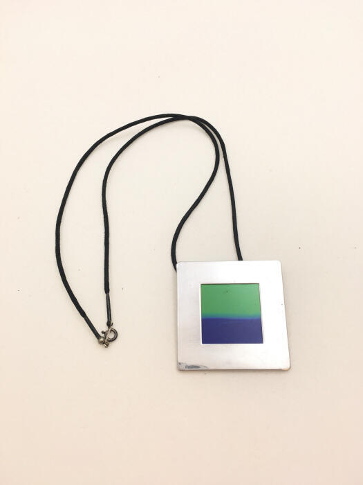 Ketting met een hanger in de vorm van een diaraampje met daarin liquid crystals