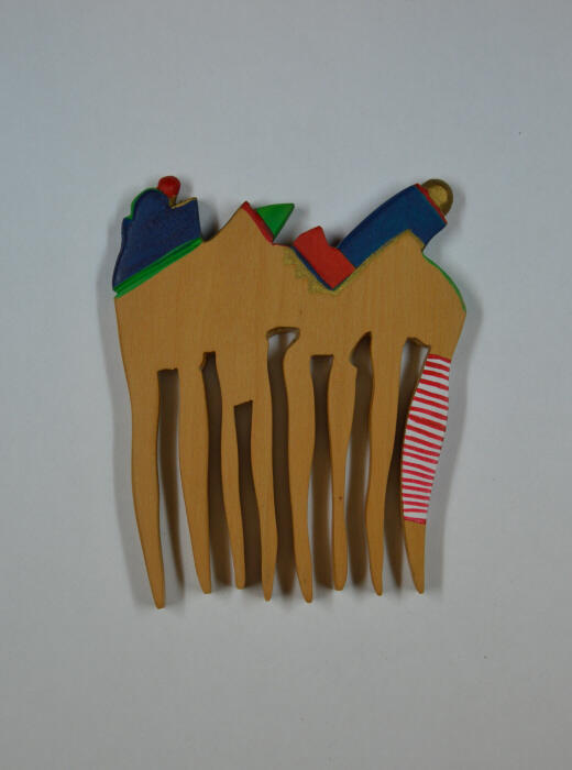 Kam van hout met gekleurde figuren aan de bovenzijde