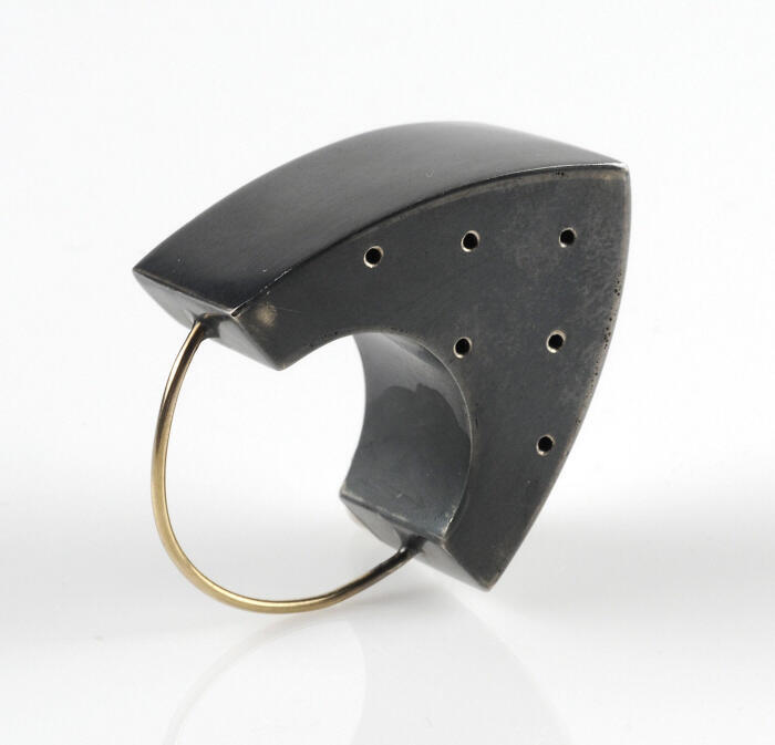 Ring van goud met versiering van gezwart zilver in de vorm van een strijkijzer