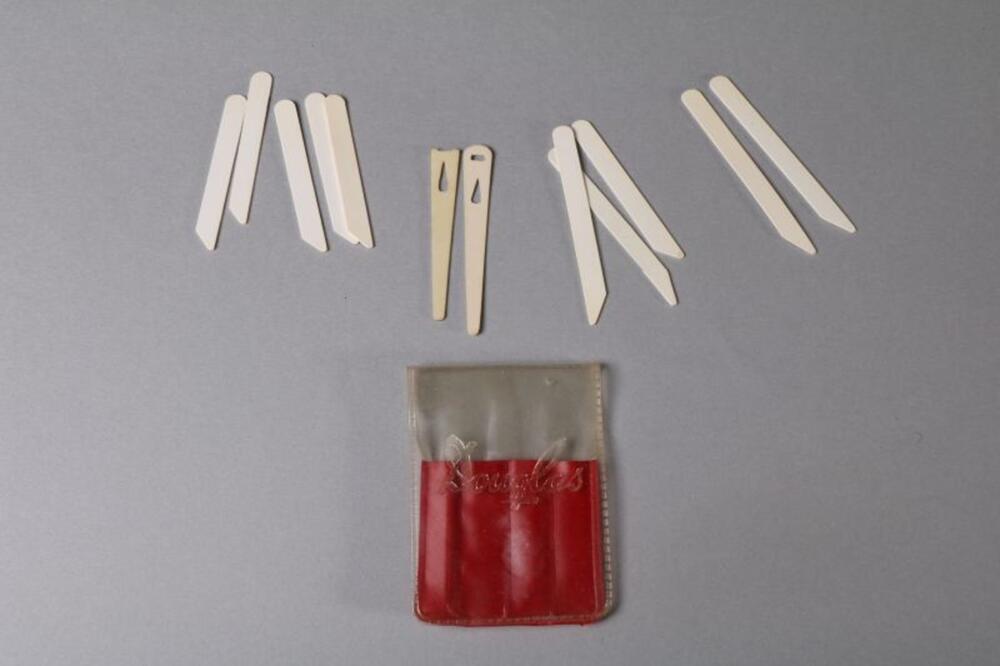Rood plastic zakje met witte kraagbaleinen voor herenhemd