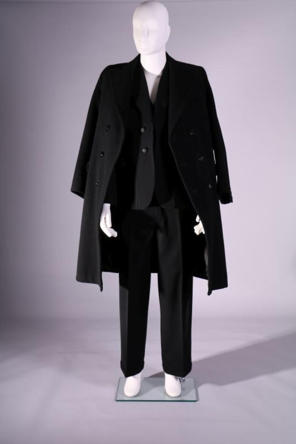 Trouwpak in zwarte wol bestaande uit broek, jasje, gilet, overjas, bolhoed, manchetknopen en…
