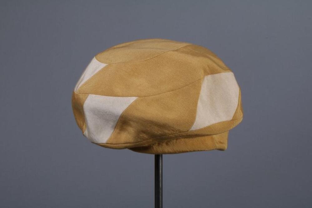 Muts in geel en ecrukleurige ottoman
