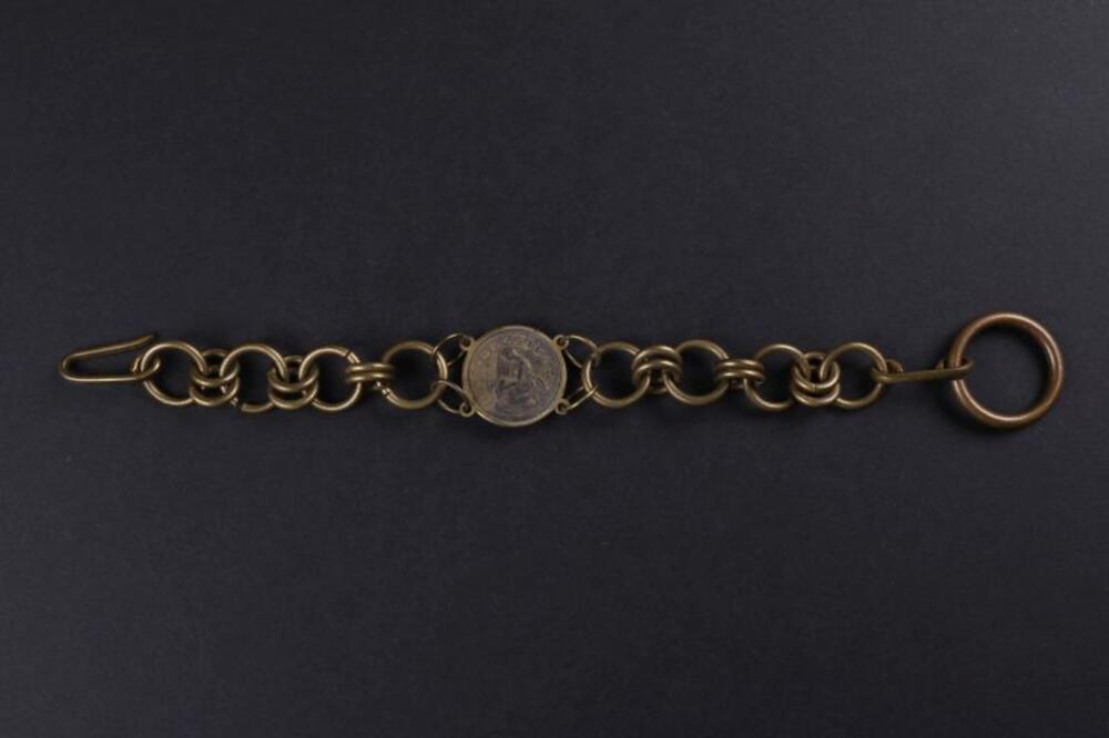 Armband in koperkleurig metaal met muntstuk