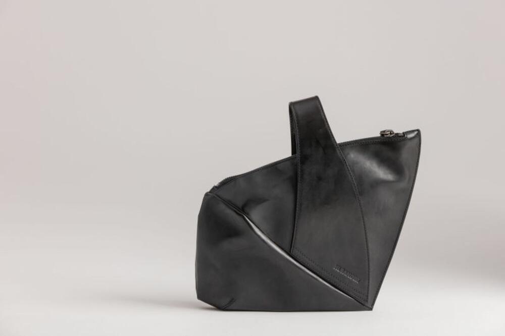 Ensemble bestaande uit handtas in zwart leer en originele zak