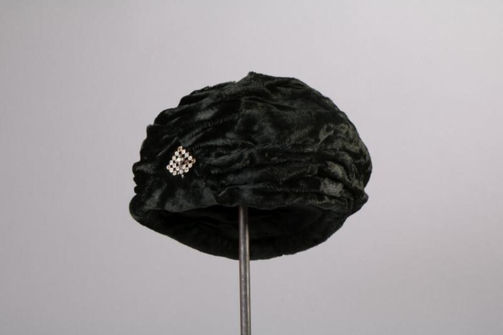 Hoed in donkergroene gedrapeerde fluweel met broche in stras
