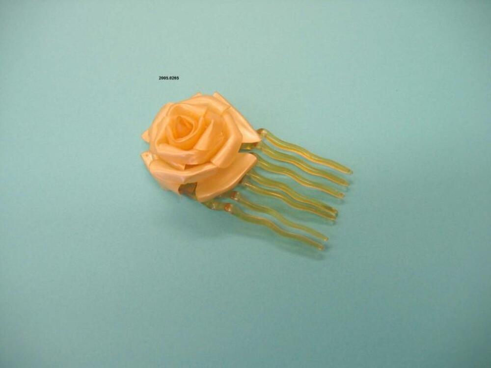 Haarkam in gele plastic met bloem decoratie
