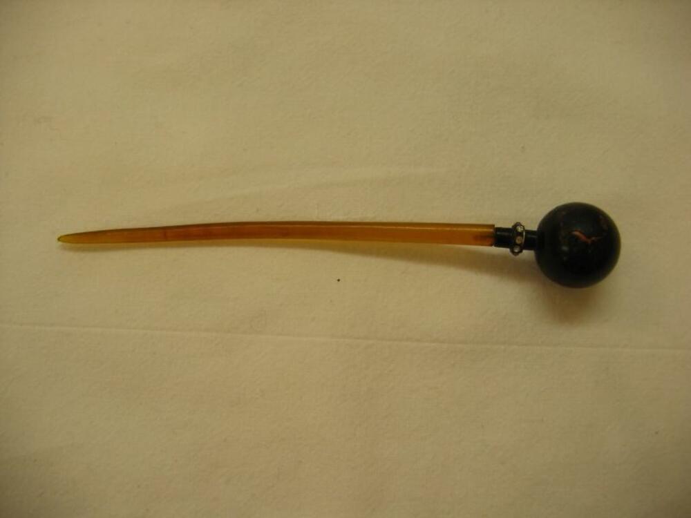 Hoedenspeld met zwarte knop en stras op een oranjekleurige pen