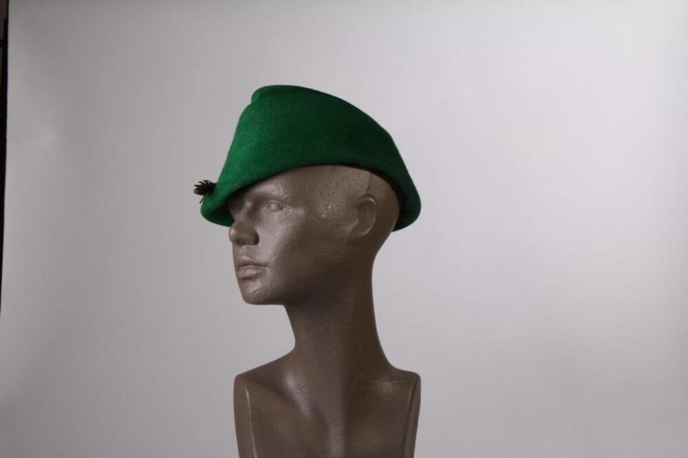 Hoed in felgroene vilt met imitatieveer in plastic en schildpad