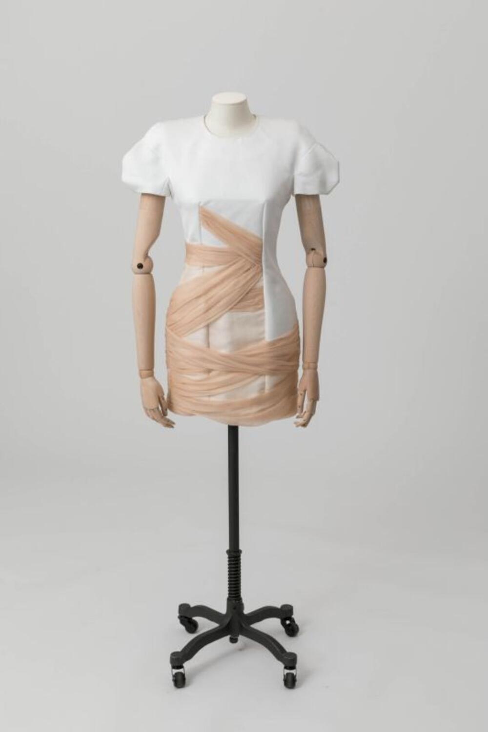 Mouwloze korte jurk in witte satijn met drapages in huidskleurige organza