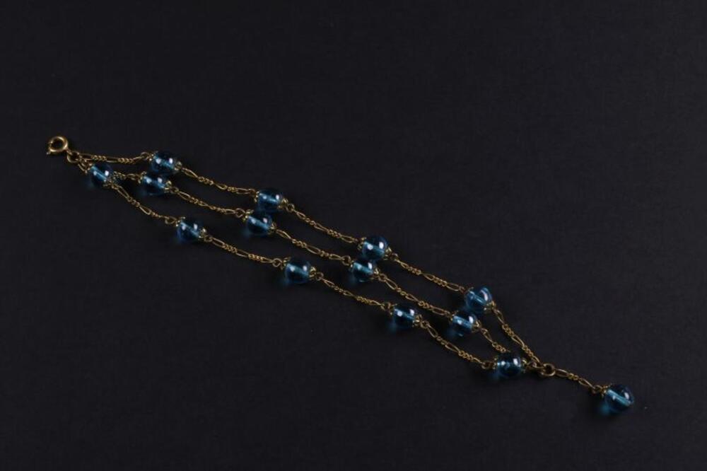 Armband in koperkleurig metaal met kralen in turkooizen plastic