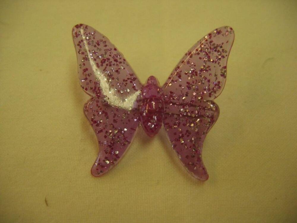 Broche in roze plastic met vlindermotief