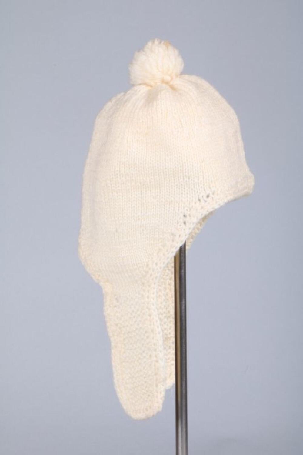 Muts in witte wol met verlengde oorlappen en pompon