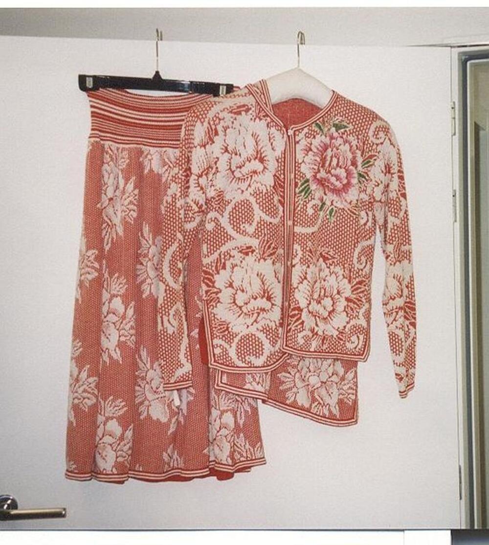 Tricot ensemble met witte bloemmotieven op rode achtergrond bestaande uit jasje, rok en topje