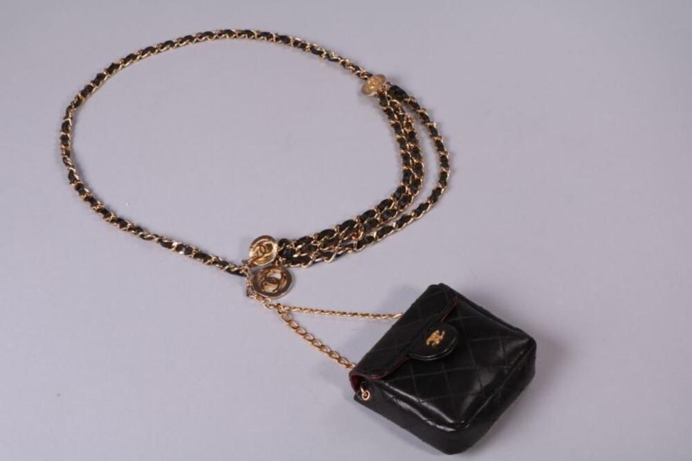 Riem in goudkleurige schakels met een kleine handtas