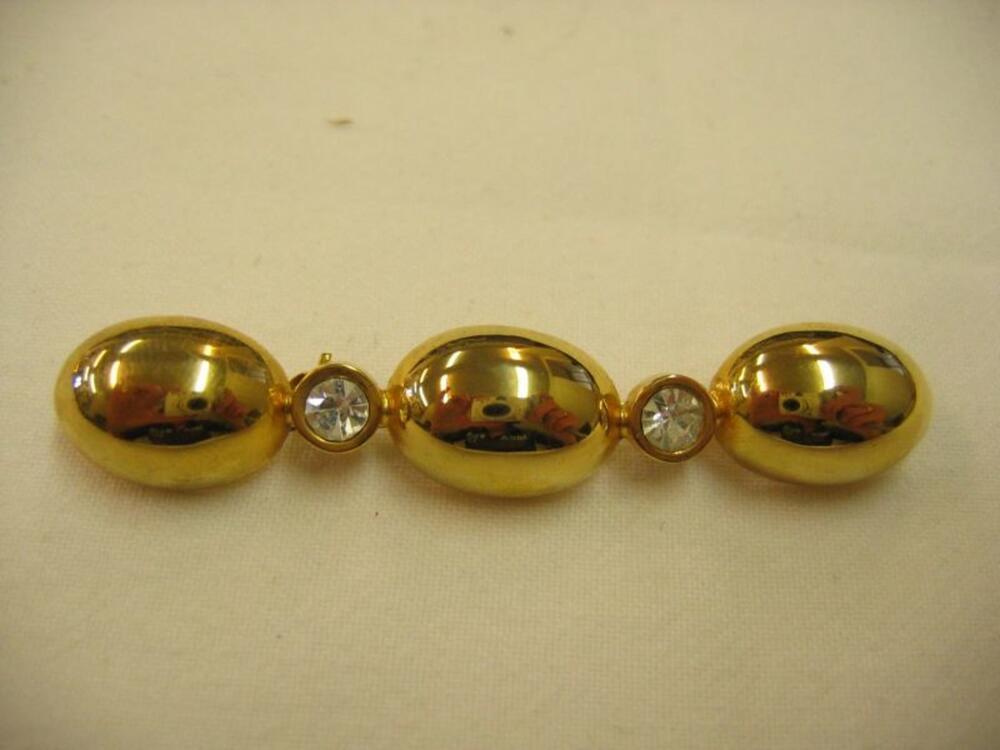 Broche in goudkleurig metaal met strasversiering