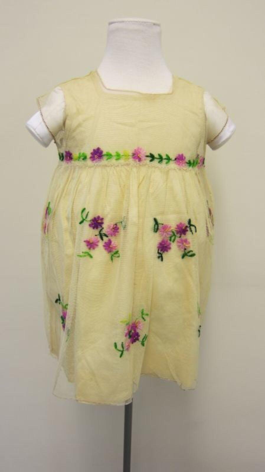 Ensemble bestaande uit onderjurk en jurk in pastelgele tule met geborduurde paarse bloemen