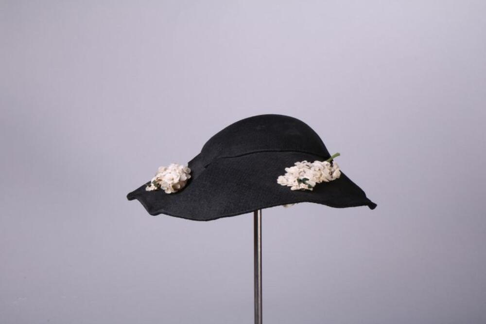 Hoed in donkerblauwe vilt met bloemendecoratie