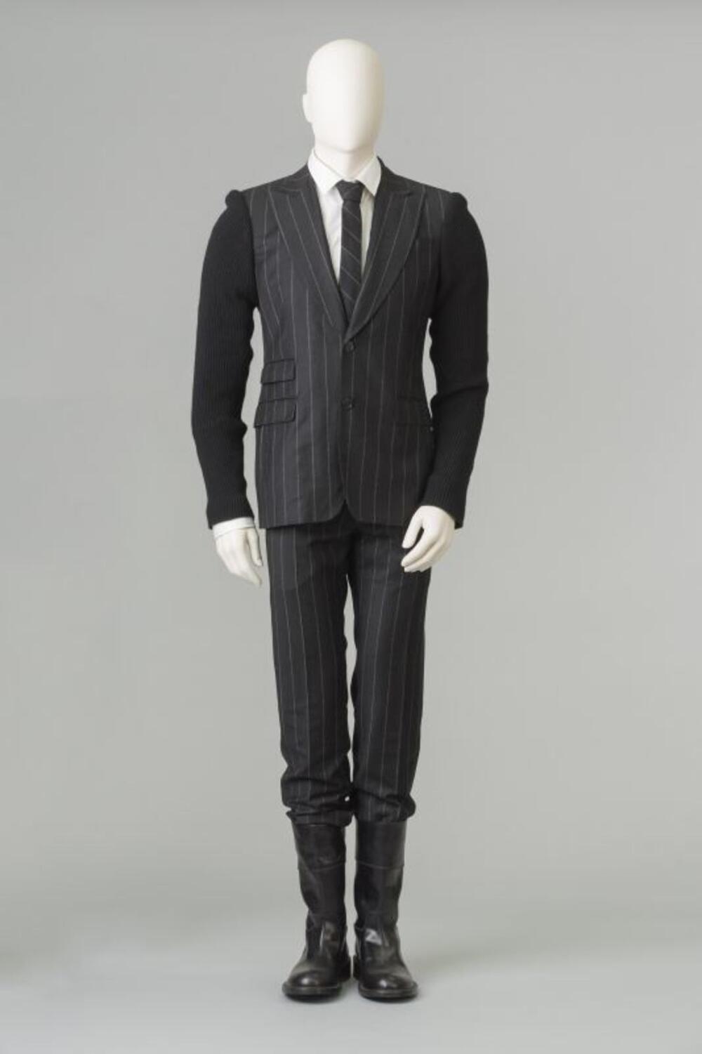 Zwart pak met jasje, broek, overhemd, das en laarzen