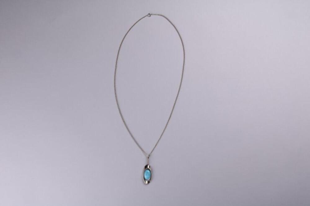 Halsketting in zilverkleurig metaal met ovale hanger met kern in turkoois