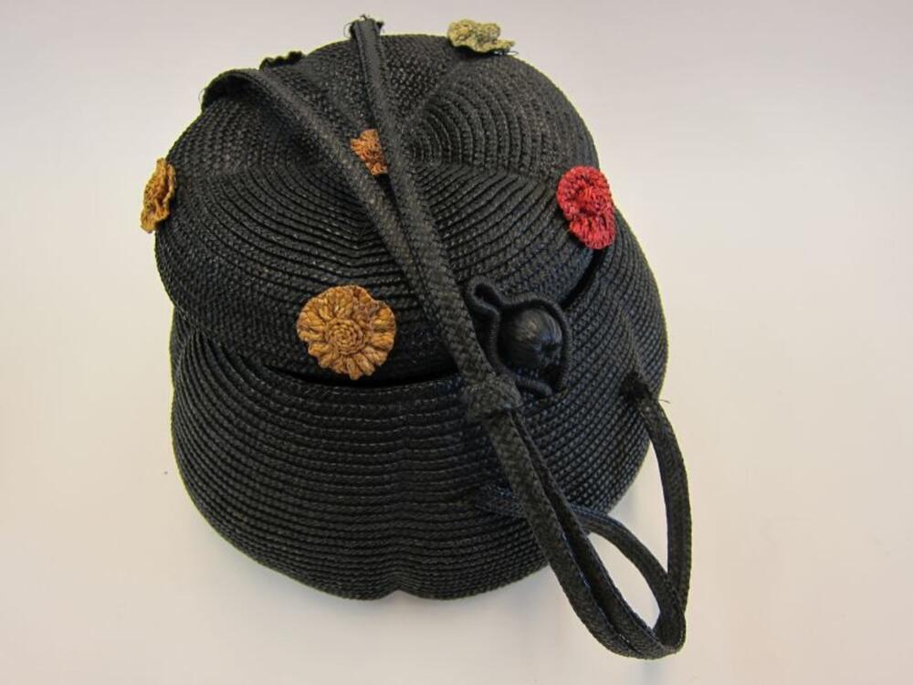 Handtas in zwart bandstro versierd met bloemen