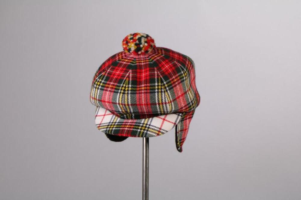 Pet in rode, groene en gele tartan met pompon