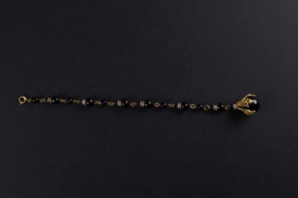 Armband van zwarte, plastic kralen in goudkleurig omhulsel