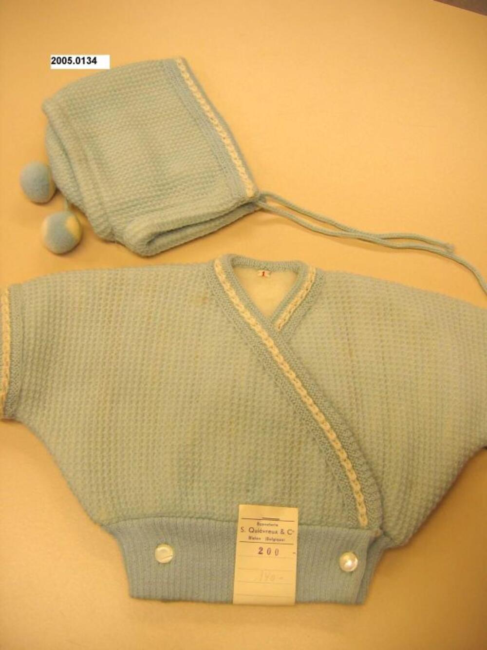 Ensemble bestaande uit cardigan en muts in lichtblauwe tricot
