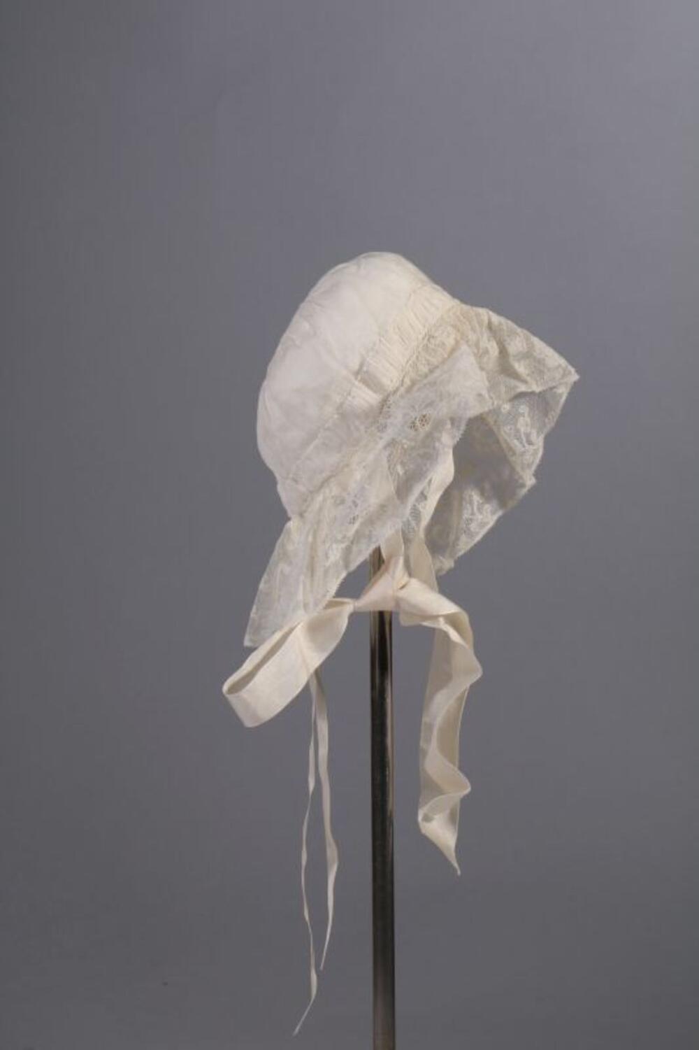 Doopensemble bestaande uit truitje in witte voile en ecrukleurige satijn en doopmuts in…
