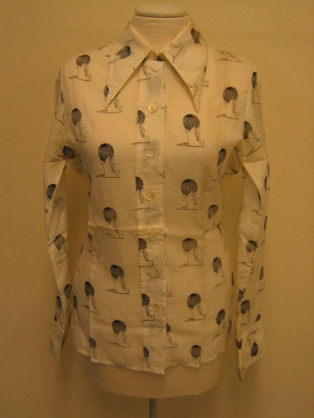 Blouse in ecrukleurige synthetische stof met zwarte bedrukking van dameshoofden
