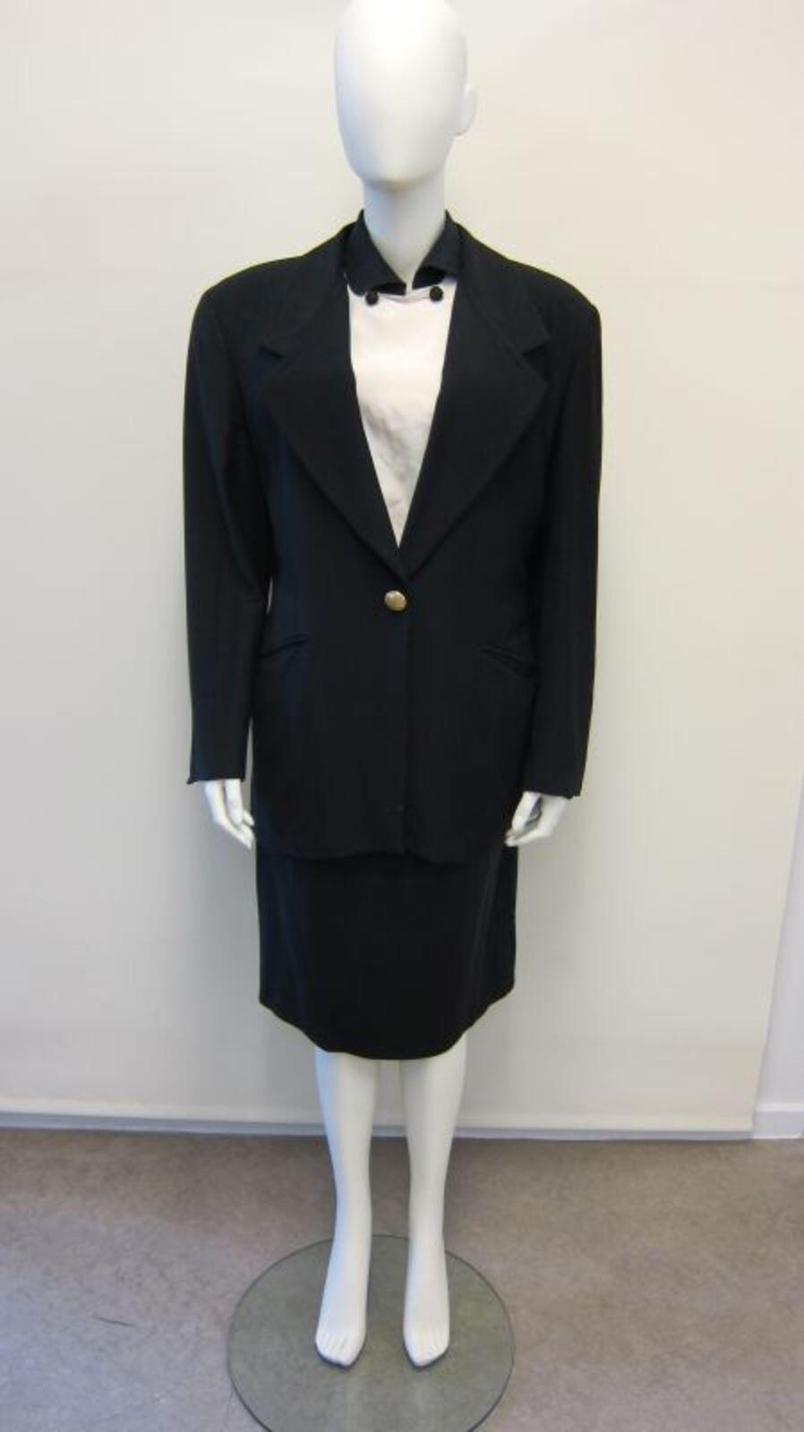 Ensemble bestaande uit jasje in zwarte wol met bijhorende riem, rok uit zwarte wol, blouse in…