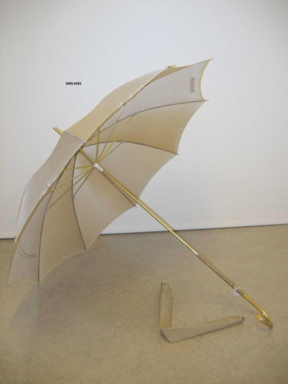 Beige paraplu met hoes en goudkleurig handvat