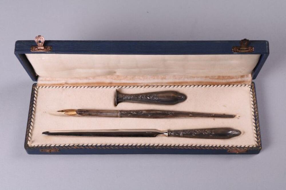 Etui in donkerblauw hout met zilveren papierensnijder, pennenstok en stempel