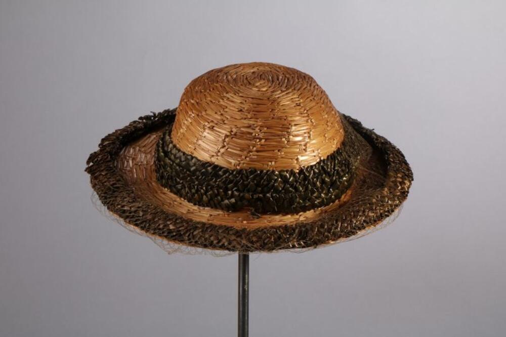 Hoed in grof geweven stro met linten in groene raffia