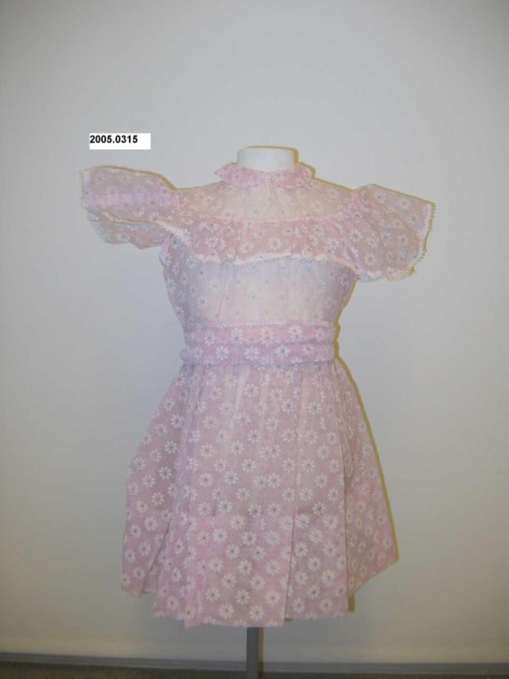 Jurk in roze nylon met witte bloemen in flockprint en riem
