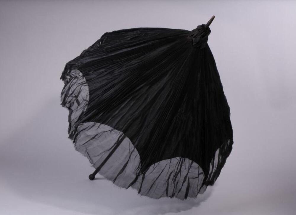 Parasol in zwarte, geplisseerde zijde met een zwart, houten handvat