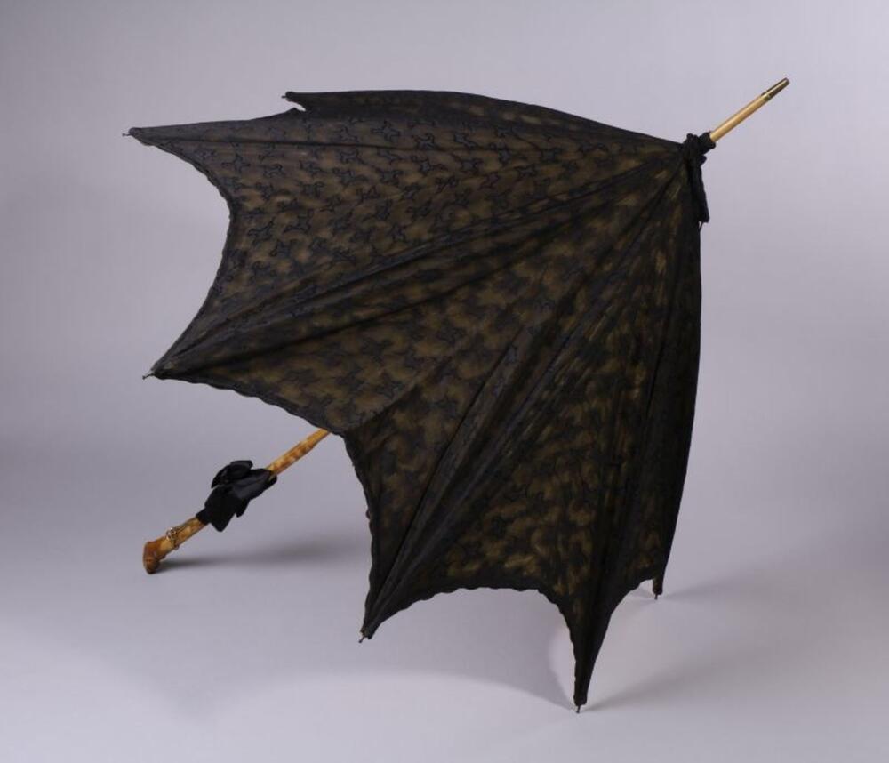 Parasol met zwart, gebrocheerd scherm over lichtgele satijn en een houten handvat