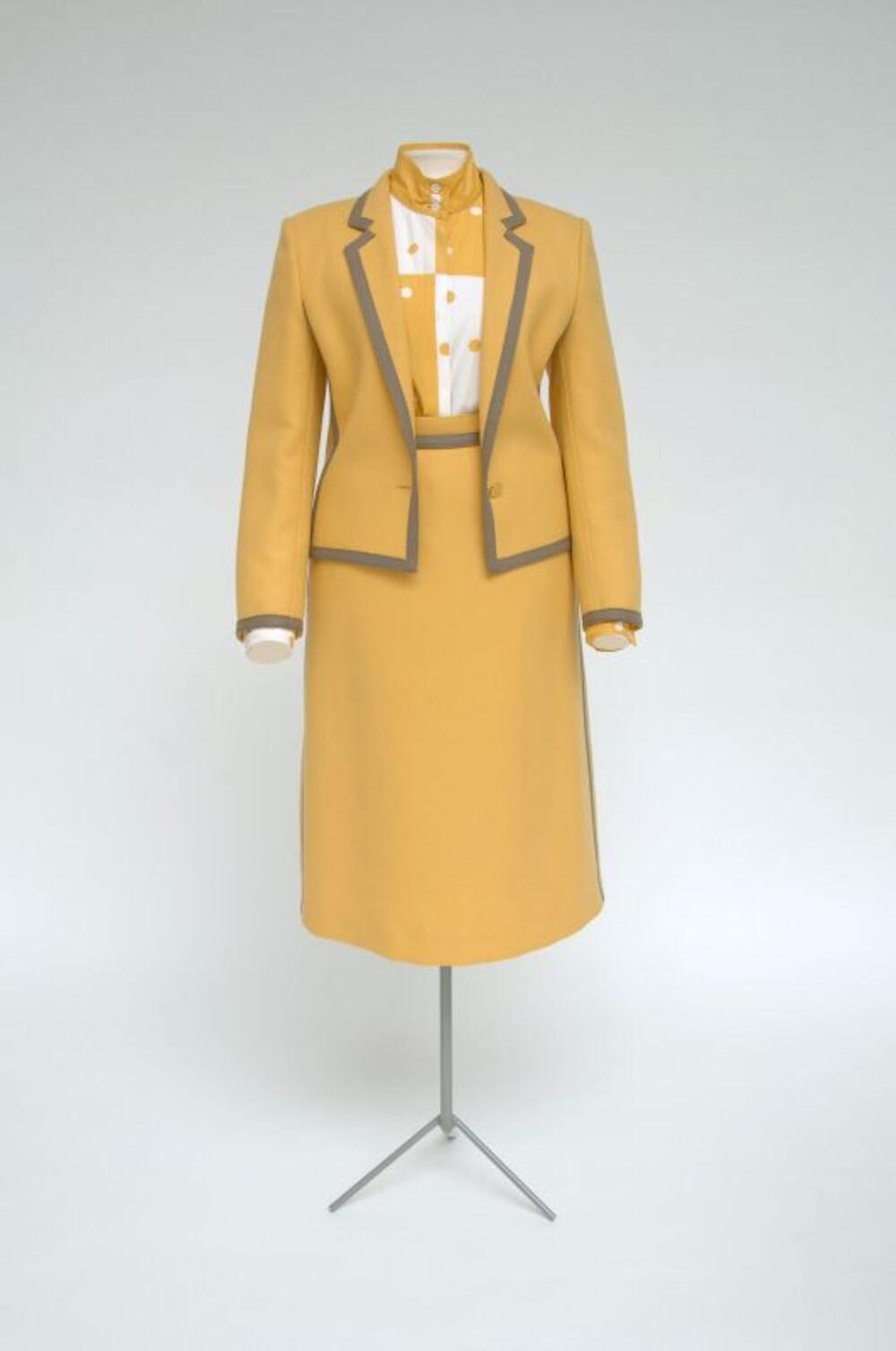 Ensemble in okergele wol bestaande uit jasje, rok en blouse